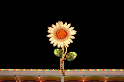 Vintage colorful sign electric flower with flashing lights at night. Abstract background.