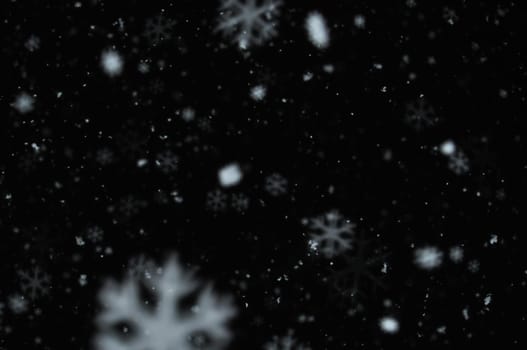 Snow on night sky abstract blur background. Snowflakes bokeh effect.