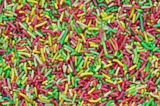 Colorful sprinkles garnish sweet candy topping abstract background.