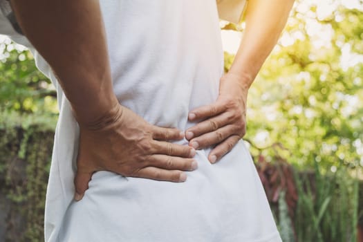 A man suffering from backache, spinal injury and muscle issue problem at outdoor.