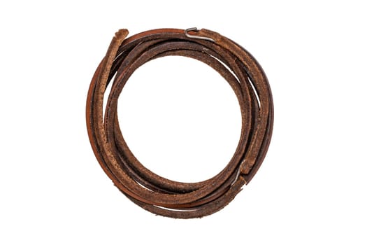 Tailoring accessories. Macro of a old leather fan belt or drive belt for a foot operated mechanical sewing machine isolated on white.