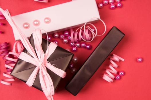 Set of gift boxes with bows, beads and ribbons on a colored background