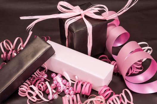 Set of gift boxes with bows, beads and ribbons on a colored background