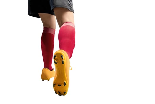 Rear view of football player woman in orange jersey kicking the ball posing isolated over white background