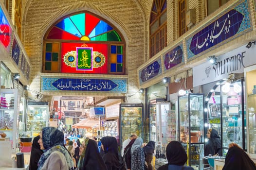TEHRAN, IRAN - MAY 22, 2017: Crowd of people in row of Grand Bazaar with stalls of dishes