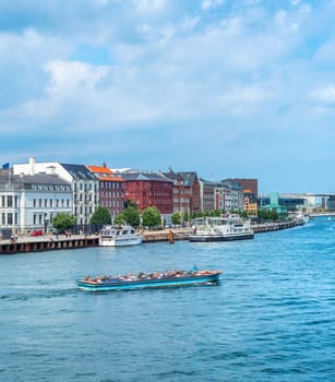 Copenhagen harbor view, boat with tourists and modern city skyline in sunshine weather with cloudy sky, Denmark