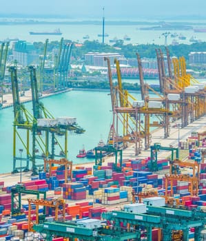 Aerial view of Singapore commercial port, stacks of shipping conteiners, freight cranes and cargo ships in harbor