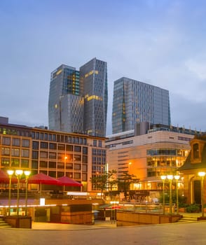 Evening cityscape of Frankfurt with illuminated downtown view, modern skyskrapers and restaurants, Frankfurt am main, Germany