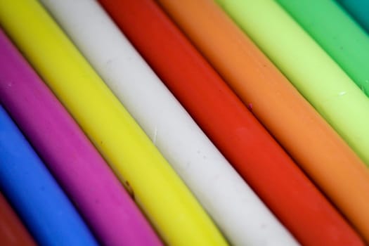 colorful children play dough lies in a row next to each other