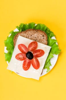 sandwich with vegetables on a white plate on a yellow background