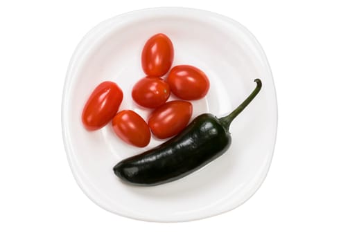 Single green jalapeno pepper and tomato cherry on plate isolated on white background