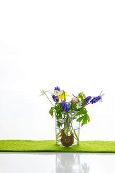 White towels next to a cream tin against a white background and flowers in a vase. Spring. Easter bunny.