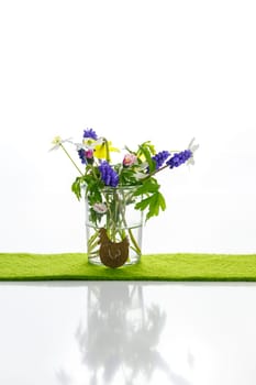 White towels next to a cream tin against a white background and flowers in a vase. Spring. Easter bunny.