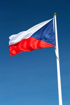 Flag of the Czech Republic close up with a clear blue sky.