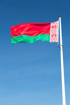 The Flag of Belarus close up with a blue sky.