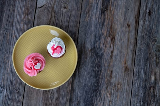 pink and white muffins on wooden ground whipping cream and heart