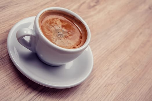 cup of coffee on wooden table from above