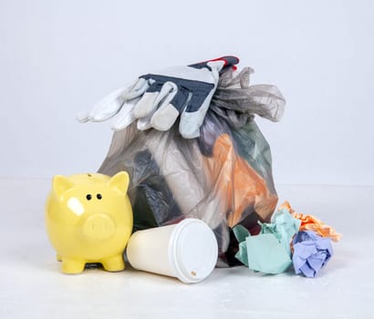 garbage bag with defferent content with yellow piggy bank
