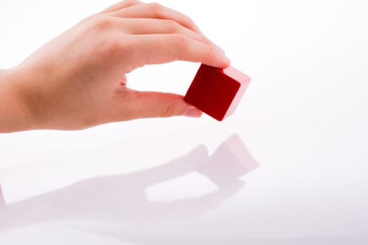 Hand playing with color cube on a white background