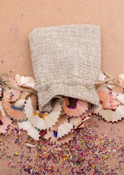 Colorful pencil shavings coming out of sack