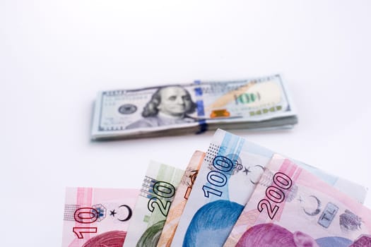 American dollar banknotes and Turksh Lira banknotes side by side on white background