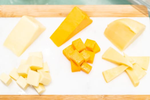 Variety of cheese on rustic wooden table in buffet line