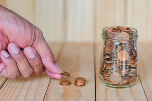 Save money and account banking for finance business concept, Hand with coin money on business office table, Savings for retirement and investing concept