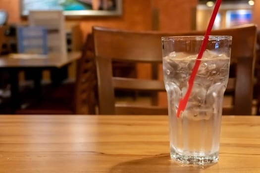 Glass water drink with tube on table blurred background