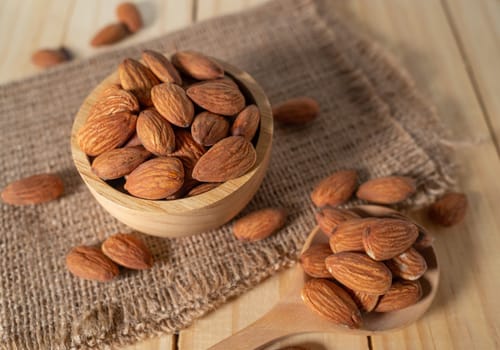 Almond snack fruit in wooden bowl on wooden table background