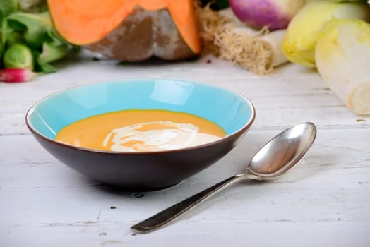 plate of pumpkin soup with  several vegetables