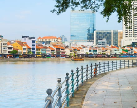 Colorful buildings of Boat Quay district and modern buildings facades view from Singapore embankment