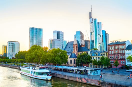 Frankfurt afterglow cityscape with modern archtecture, business district skyscrapers,  restaurants, tour boat at Main river, Germany