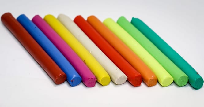 colorful children play dough lies in a row next to each other