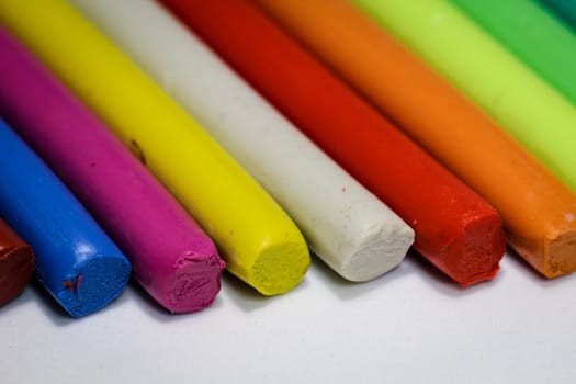 colorful children play dough lies in a row next to each other