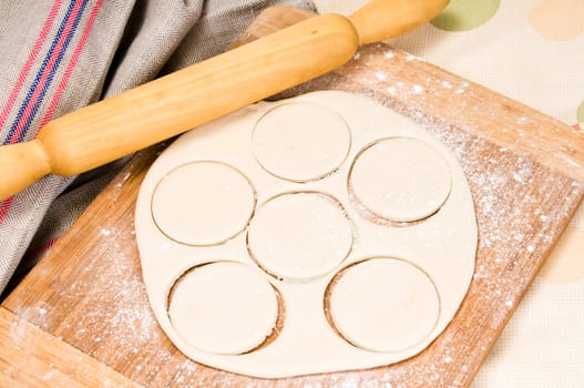 fresh raw dough and rolling pin for baking