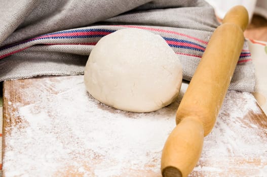 fresh raw dough and rolling pin for baking