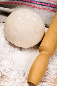 fresh raw dough and rolling pin for baking
