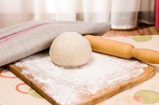 fresh raw dough and rolling pin for baking