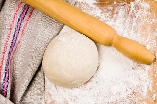 fresh raw dough and rolling pin for baking