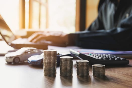 Car insurance and car service with stack of coins. Toy car for accounting and financial concept.
