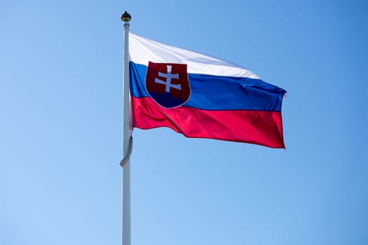 The Flag of Slovakia Waving in the Wind on flagpole.