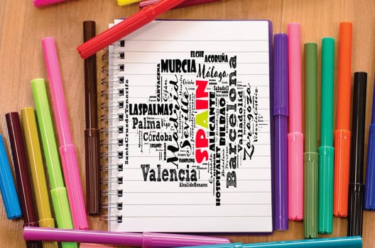 Cities in Spain word cloud over notepad background travel concept