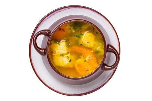 Seafood background. Macro of freshly cooked Mediterranean fish soup with salmon and shrimps in a brown ceramic bowl on plate isolated on a white background. Advertising. Top view.