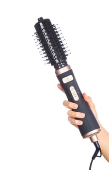 Hand holding hair curling iron round brush isolated on white background