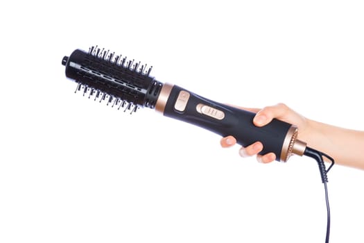 Hand holding hair curling iron round brush isolated on white background