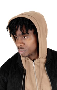 A handsome black man in a beige hoody and black jacket in close up.looking serious sideward, isolated for white background.