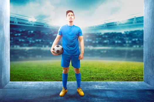 Asian football player man holding the ball in the stadium hallway before enter the field on stadium