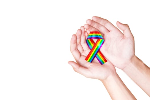 Human hands holding ribbon with rainbow flag as a symbol of LGBT isolated over white background