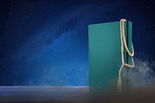 Quran and prayer beads on wooden table at outdoor with night scene background