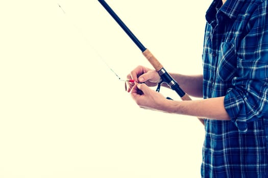 man with fishing rod and blue plaid shirt in front of white background